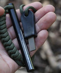 Close-up of Survival Ferro Rod Fire Starter Kit with drilled ferrocerium rod, 4 inch long, paracord lanyard, Striker Pro attached.