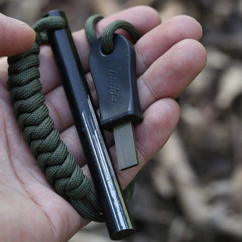 Close-up of Survival Ferro Rod Fire Starter Kit with drilled ferrocerium rod, 4 inch long, paracord lanyard, Striker Pro attached.