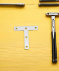 Beefy Heavy Duty Stainless Steel Corner Bracket Plates with tools on yellow surface, T shaped for metal and wood panels