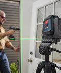 GLL50-20G 50 Ft Green-Beam Self-Leveling Cross-Line Laser with magnetic mount on tripod in construction setting