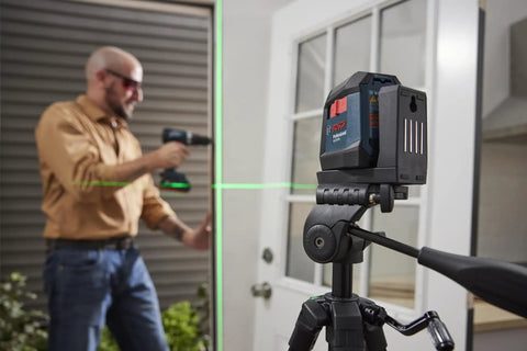 GLL50-20G 50 Ft Green-Beam Self-Leveling Cross-Line Laser with magnetic mount on tripod in construction setting