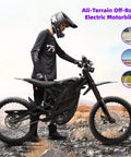 Badass 8000W Electric Dirt Bike For Adults With 75 Mile Range And 60 Mph Top Speed 19 Inch Fat Tire Offroad Ebike parked on rocky terrain.