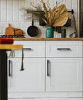 Five Inch Black And Gold Knurled Cabinet Pulls Set Of Ten Heavy Duty Drawer Handles installed on white kitchen cupboards
