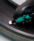 Close-up of Straight Shooter Air Die Grinder Kit being used on a tire, showcasing pneumatic polishing while wearing gloves.