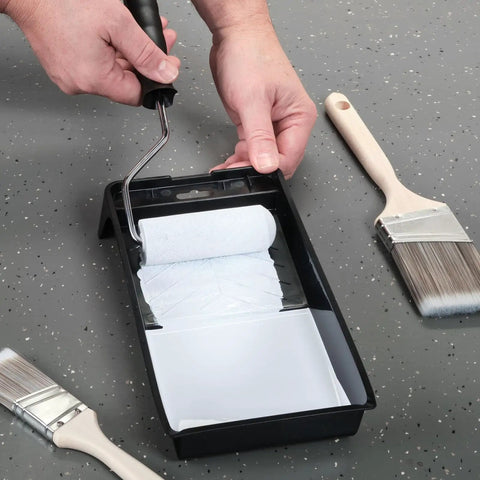 Person using roller on 4 Inch Paint Tray Pan Set 12 Pack Black Spill Resistant Mini Trays With Dual Wells For Rollers And Roller Pan Disposable