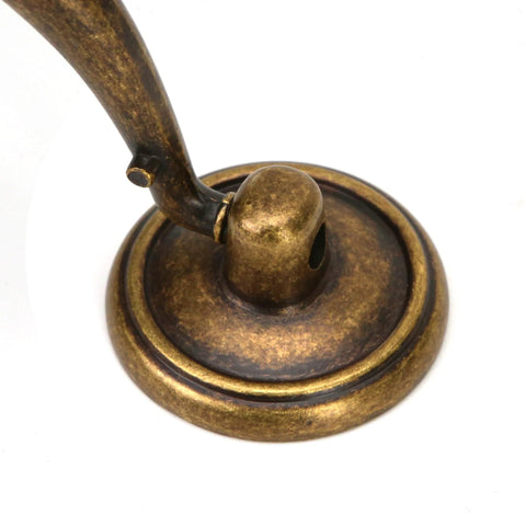 Base of vintage drop bail drawer pull handle in antique bronze finish, zinc alloy material for cabinets and desks, close-up view.
