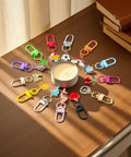 Super Vibrant Sixty Piece Zinc Alloy Keychain Clips With Swivel Lobster Claw Clasps arranged around a candle on a table.