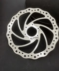 180mm Bicycle Disc Brake Rotor With Flange Adapter For Threaded Hubs Stainless Steel 2mm Thick Silver Finish on dark surface