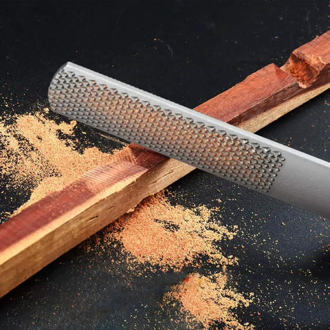 Round file from Two Pack 4 Way Wood Rasp File Set With Premium High Carbon Steel used on wood with sawdust visible