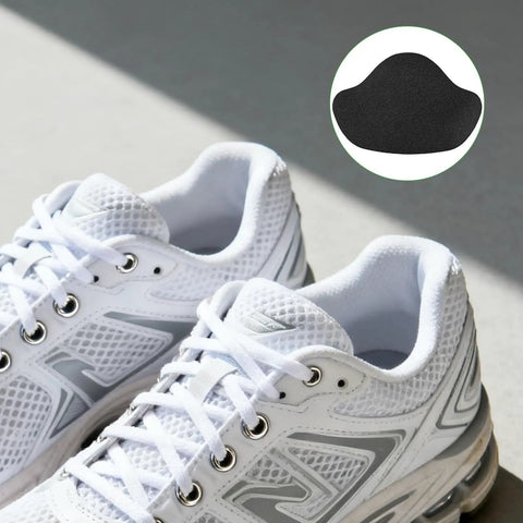 Self Adhesive Inside Shoe Heel Patches 12 Pack For Quick Hole Repair Black Interior Shields Breathable Comfort Fit To Stop Worn Areas From Spreading In Most Shoes visible next to white athletic sneakers.