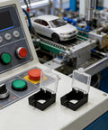 Emergency Stop Button Guard Cover for 22mm Push Switches on control panel with machinery in background