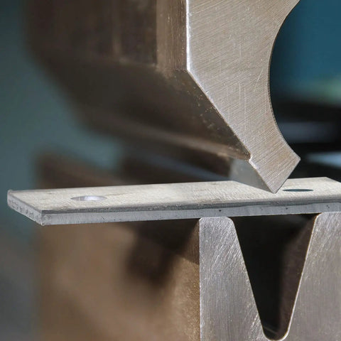 Close-up of 4 Pcs Hot Rolled ASTM A36 Steel Plates Half Inch Thick 4X4 Inch in a metal press for drilling and welding DIY metalworking.
