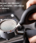 Hand using silicone air blower on portafilter from 7 Piece Espresso Tools Kit For 54mm Breville Portafilters Includes 53.3mm Tamper Distributor Puck Screen Dosing Funnel WDT Tool Perfect Home Barista Gear