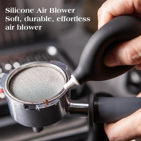 Hand using silicone air blower on portafilter from 7 Piece Espresso Tools Kit For 54mm Breville Portafilters Includes 53.3mm Tamper Distributor Puck Screen Dosing Funnel WDT Tool Perfect Home Barista Gear