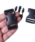 Four Pack 1 Inch Quick Side Release Buckles Dual Adjustable No Sew Clips for nylon webbing replacement, held in hand, showing details.