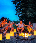Group enjoying evening with lit butterfly luminary bags and flameless LED tealights set of 50 each white outdoor lanterns.