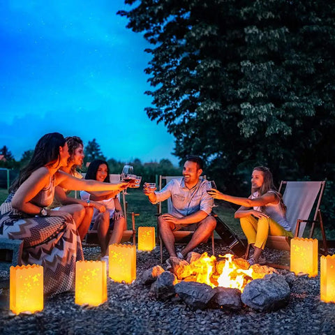 Group enjoying evening with lit butterfly luminary bags and flameless LED tealights set of 50 each white outdoor lanterns.