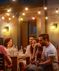 Group enjoying evening outdoors with Dusk To Dawn Porch Light With Built In GFCI Outlet Black Outdoor Wall Sconce illuminating scene