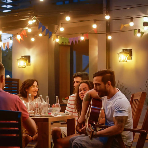 Group enjoying evening outdoors with Dusk To Dawn Porch Light With Built In GFCI Outlet Black Outdoor Wall Sconce illuminating scene