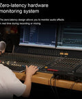 Person using Pro Grade USB Audio Interface With 4 In 4 Out And Dual Headphone Outputs, viewing zero-latency monitoring system
