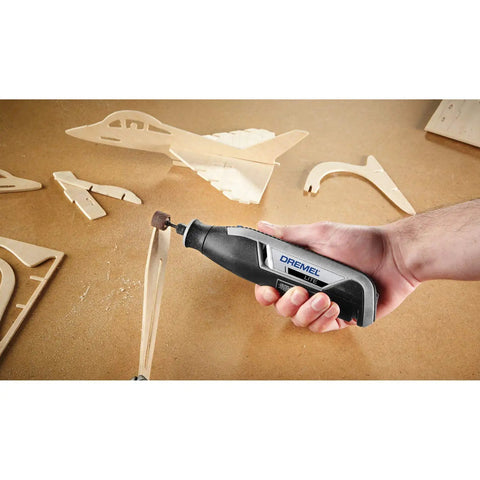 Hand holding Ultra Compact Four Volt Cordless Rotary Tool Featuring Variable Speed And No Sweat Accessory Swaps for crafting wood models.
