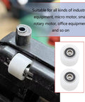 Close-up of two-pack nylon sliding pulley bearings 40x30mm with 6000ZZ on metal track in industrial setting.