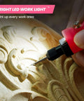Pink HARDELL mini cordless rotary tool with engraving bit carving wood, close-up view