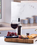 Heavy Duty Rubber Feet For Cutting Board With Stainless Screws 20 Pack on a kitchen countertop with wine and snacks.