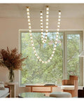 Sick Diamond Drop Pendant Light Featuring Hella Sleek Dimmable Led Design With Polished Gold Hardware And Sparkling Glass Shades above a modern living space.