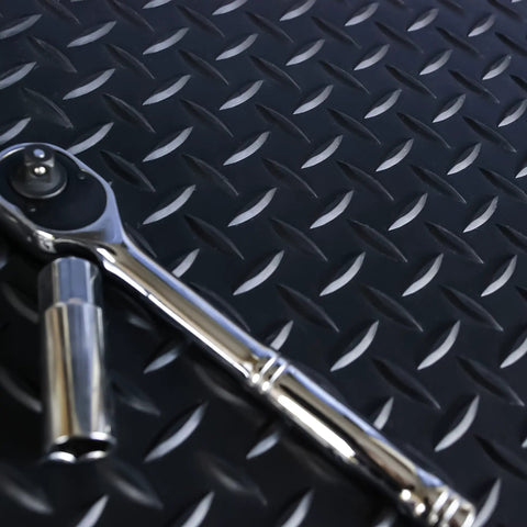 Commercial Grade Vinyl Diamond Plate Floor Mat Knockout Traction Tough As Nails Oil And Chemical Resistant Protection For Heavy Traffic Garages Professional Workshops Black Yellow Border with ratchet tool on mat.
