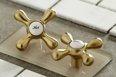 Close-up of brushed brass hot and cold knobs for Magellan 6 Inch Adjustable Center Wall Mount Kitchen Faucet, detail view