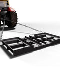 Heavy Duty Tow Behind Workhorse Harrow Rake For Driveways And Lawns, 4 Foot Drag Lawn Grader attached to a tractor, black