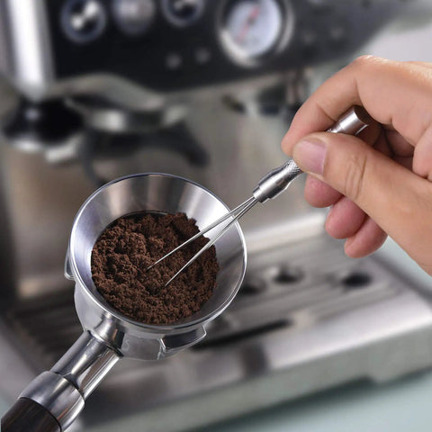 Hand using Espresso Coffee Stirrer Stainless Steel Mini Whisk for espresso stirring and distribution in portafilter basket.