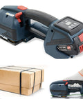 Slick Automatic Tying Rig That Fast Tracks Every Job With No Sweat Performance Using Auto Melting Technology And 4000Mah Battery Fits Half To Eighths Inch Straps Portable Handheld Baler Unit next to a bundled cardboard box.