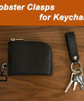 Hella Durable One Inch Zinc Alloy Swivel Snap Hooks With Pro Level Lobster Claw Clasps For Daily Carrying And Crafting Bringing A Crisp Black Feel To Any Project Six Pack attached to a black wallet and keychain.