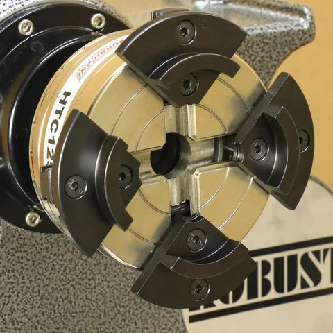 Close-up of HTC125 5 Inch Four Jaw Woodturning Chuck Kit mounted on lathe, showing chrome-plated steel body and dovetail jaws.