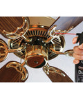Hand using Compressed Gas Cleaning Duster 152a 10 Oz Can 3 Count With Bitterant For Inhalant Abuse Deterrence on ceiling fan