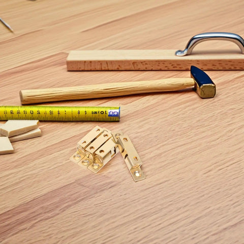 Double Ball Tension Roller Catch Latch Brass Hardware Set 4 pieces on wood surface with tools visible