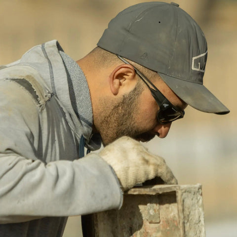 Worker wearing Polarized Wraparound Safety Glasses Built Tough for Work and Outdoors with blue mirror lens, adjusting equipment.