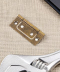 Image of a Vintage Style Small Stainless Steel Flush Mount Cabinet Hinge with thickened iron on fabric background