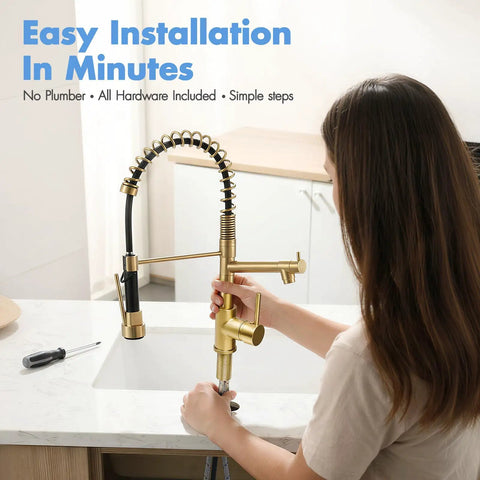Person installing AIMADI Brushed Gold Kitchen Faucet with Pull Down Sprayer on a white sink in a modern kitchen.