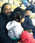 Child wearing 34dB NRR Ear Protection Muffs at sports event, highlighting compact, adjustable safety for kids and adults.