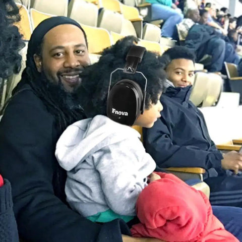 Child wearing 34dB NRR Ear Protection Muffs at sports event, highlighting compact, adjustable safety for kids and adults.