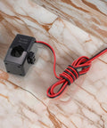 Premium Split Core Current Transformer Clamp Sensor 200A with wires on marble surface for EV charging stations and grid tracking.