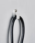 Cable management hook on aluminum wall, holding a black power cord, part of Top Shelf Pro Kitchen Beast Half Size Holding And Proofing Cabinet UL and NSF Certified.