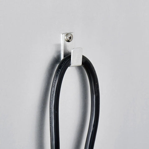 Cable management hook on aluminum wall, holding a black power cord, part of Top Shelf Pro Kitchen Beast Half Size Holding And Proofing Cabinet UL and NSF Certified.