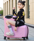 Pink kids ride-on suitcase with wheels; child sits on it outdoors.