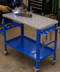 Boss Level Portable Welding Table 36 By 18 Inch Steel Workbench with welding sparks and tools in use.