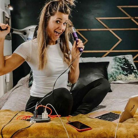 Woman using 10 Foot Flat Plug Extension Cord With USB Port, Three Widely Spaced Outlets on bed, powering devices, home setup.