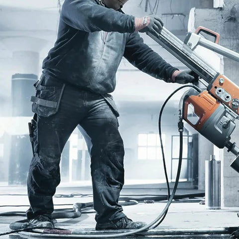 Side view of a worker using a 6 ft black HVAC vacuum hose with 3/8–1/4 in fittings attached to an orange refrigerant pump.